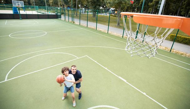 Mutlu baba oğlunun basket atmasına yardım ediyor. - Fotoğraf, Görsel