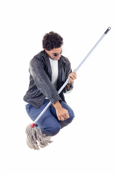 man in leather jacket jumps with a broom - Zdjęcie, obraz