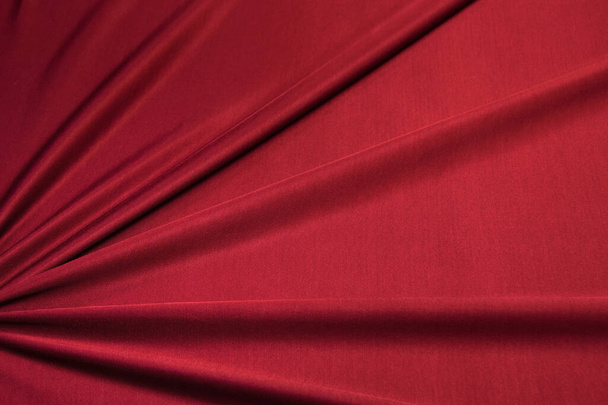 Červené zářivé pletené oblečení. Přikrytá tkanina s záhyby, dres, může být použit jako pozadí - Fotografie, Obrázek
