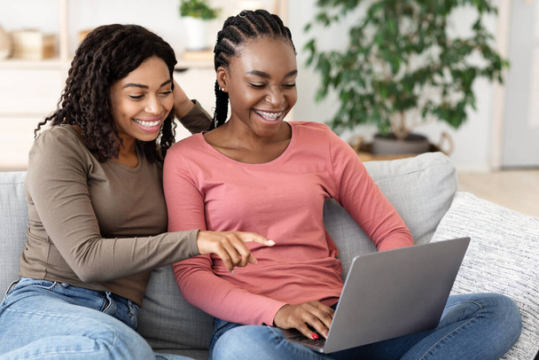 Szczęśliwy czarny kobiety za pomocą laptopa w domu, websurfing - Zdjęcie, obraz