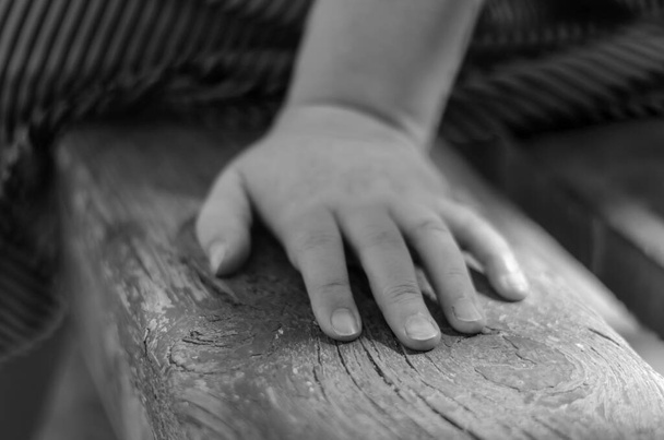 Close-up of a female hand on a park bench. An adult woman sits alone on a park bench. Love and relationship concept. Selective focus. - Photo, Image