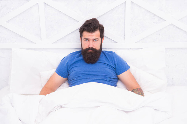 brutal male spending time in room. relax lifestyle concept. bearded man in bed. wake up at morning. bachelor feel comfortable. guy single at bedroom. lazy sunday. bed time routine - Foto, afbeelding