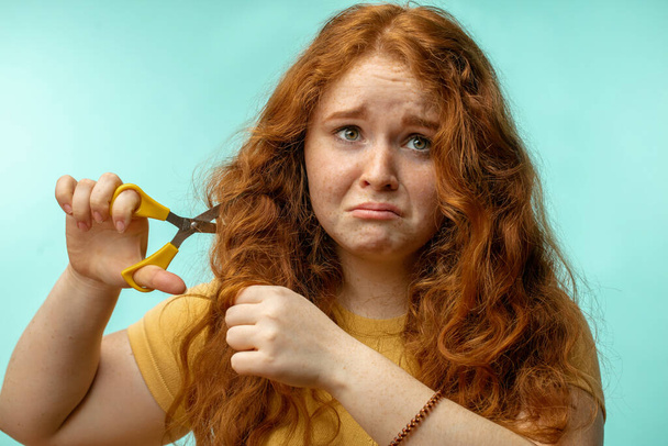Upset and woman with her damaged dry hair face expression blue background - Photo, image