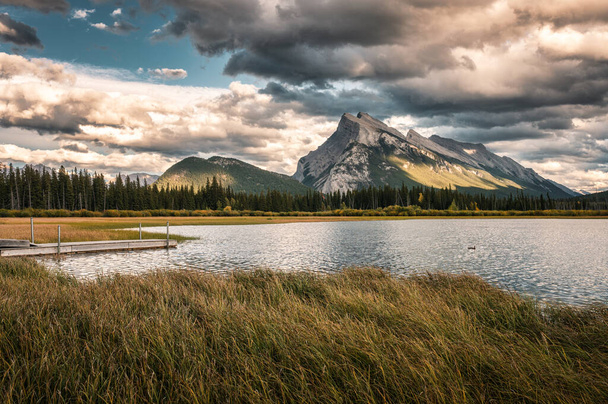 Mount Rundle with cloudy and wooden pier in Vermillion lake at Banff national park, Canada - Фото, изображение