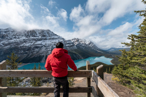 Férfi télikabátban áll, és néz a kilátás nyílik a Peyto-tó Banff Nemzeti Park, Kanada - Fotó, kép