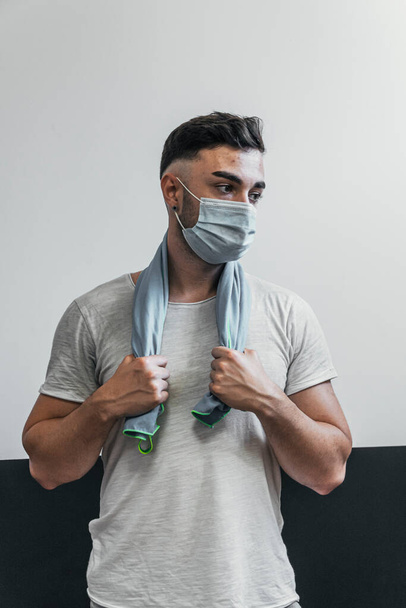 fitness boy holding towel with mask - Foto, imagen