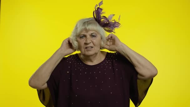 Ενοχλημένη ηλικιωμένη γυναίκα που καλύπτει τα αυτιά και κάνει χειρονομίες Όχι, αποφεύγοντας συμβουλές, αγνοώντας το θόρυβο - Πλάνα, βίντεο
