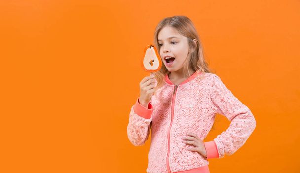 Girl smile with lollipop on orange background - Фото, зображення