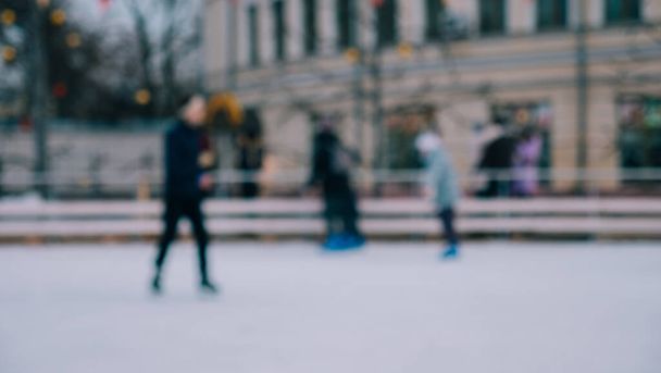 Defokus. Muži ženy děti bruslí na ledě v zimě. Lidé dělají amatérské sporty - Fotografie, Obrázek