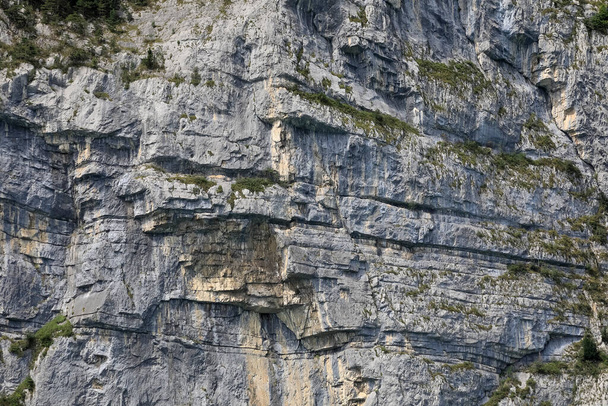 La surface d'une montagne rocheuse avec des couches géologiques rocheuses multicouches et des traces d'érosion. C'est un détail des Alpes suisses. - Photo, image