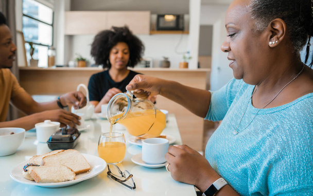 Portrait of African american family having breakfast together at home. Family and lifestyle concept. - Фото, зображення