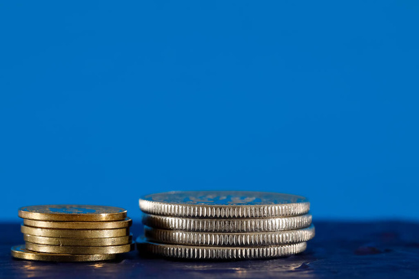 Кілька швейцарських монет на синьому фоні. Поверхня, на якій розміщені ці монети, темно-синя.. - Фото, зображення