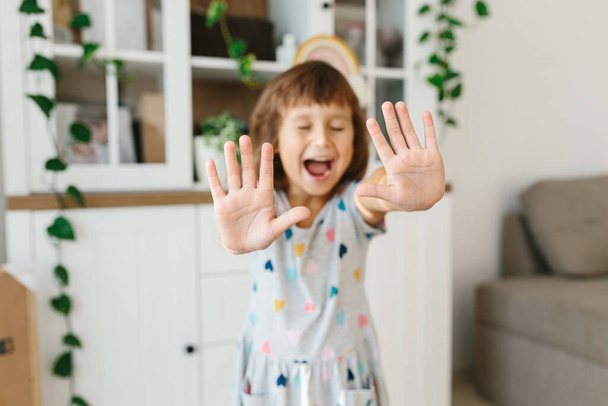 Disinfecting hands. Child girl using showing hands after disinfection alcohol gel on hands home living room background to prevent virus epidemic. Selective focus hands - Valokuva, kuva