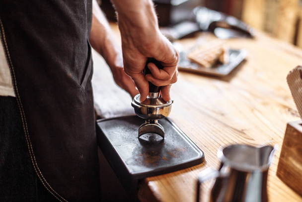 barista is pressing coffee beans with tamper - Photo, image