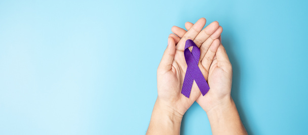 膵臓癌,世界アルツハイマー,てんかん,ループスと家庭内暴力の日啓発月,生活をサポートするための紫色のリボンを保持する女性.医療と世界のがんの日のコンセプト - 写真・画像