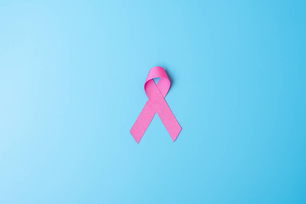 10月乳がん啓発月、生活や病気を支援するための青の背景にピンクリボン。国際女性、母と世界の癌の日の概念 - 写真・画像