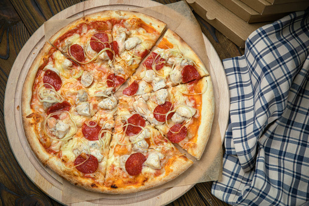 Pizza, in stock. on a brown wooden table. - Foto, afbeelding