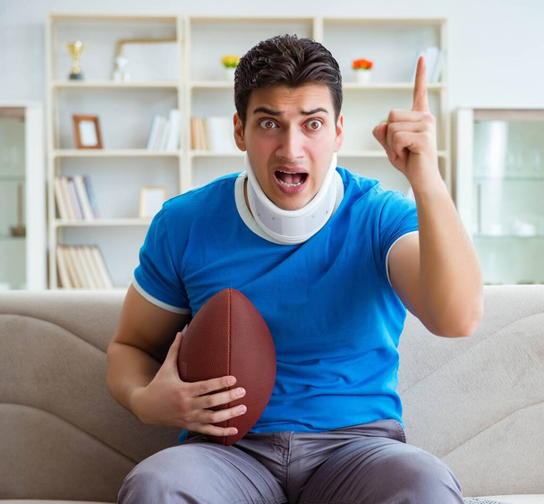 Чоловік з травмою шиї дивиться американський футбол вдома. - Фото, зображення