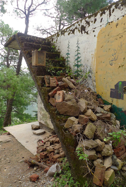 Egy lerombolt régi épület Dharamsala mellett Indiában, egy rozoga lépcsőházzal, amin törmelék van. - Fotó, kép