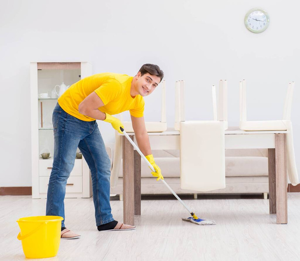 jeune homme faisant des tâches ménagères à la maison - Photo, image