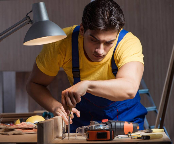 Worker working in repair workshop in woodworking concept - Foto, Bild