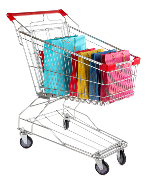 Colorful shopping bags in shopping trolley, isolated on white - Foto, Imagen