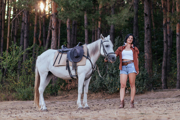 秋に芝生の上で馬とカウボーイのイメージの女の子  - 写真・画像