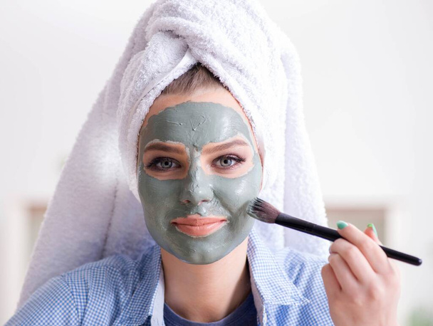 Woman applying clay mask with brush at home - Foto, Imagen