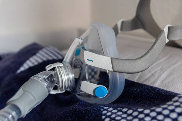 CPAP-Maske gegen obstruktive Schlafapnoe auf Kopfkissen hilft Patienten als Beatmungsmaske und Kopfbedeckungsclip für Atemmedikamente mit einem cpap-Gerät gegen Schnarchen und Schlafstörungen beim Atmen - Foto, Bild
