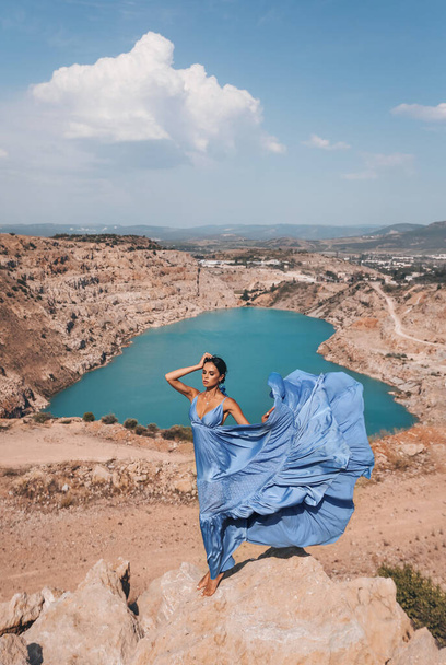 fashion outdoor photo of beautiful sexy woman with dark hair in elegant dress and accessories posing in beautiful landscape with a lake with heart shape - Zdjęcie, obraz