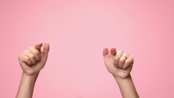man holding hands in the air, pointing fingers and making thumbs up gesture, dancing on pink background - Footage, Video