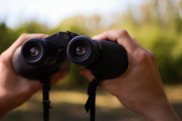 Hands holding binoculars. Forest hiking. Bird watching. Searching for opportunities concept. Adventure quest - Foto, afbeelding