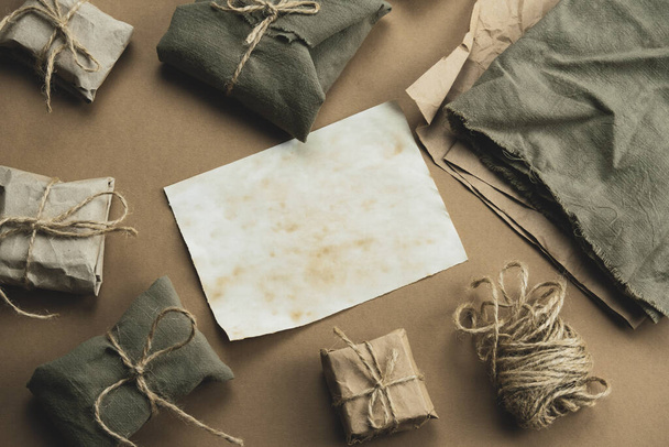 top view zero waste gift boxes wrapped in paper and textile on a brown background copy space - Foto, afbeelding
