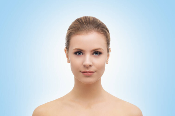 Face of a beautiful girl over blue background. Plastic surgery, skin lifting, spa, cosmetics and medicine concept. - Foto, afbeelding