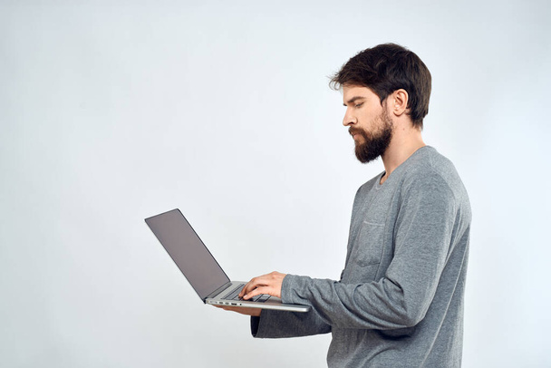 Un hombre en un suéter gris con un portátil manos estilo de vida tecnología comunicación internet trabajo - Foto, Imagen