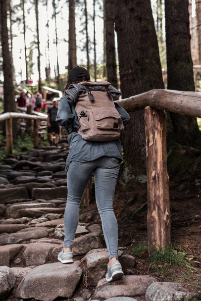 woman hiker walking by stone trail in forest with backpack - Fotografie, Obrázek