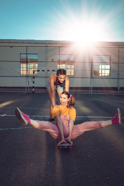 Two teen girls have fun with skate board - Fotoğraf, Görsel