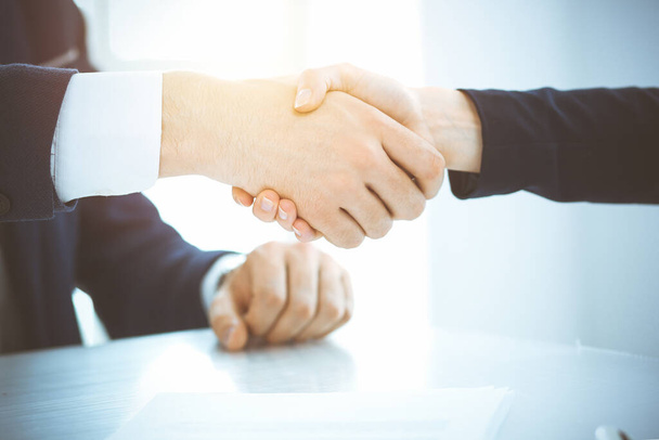 Business people shaking hands finishing up meeting or negotiation in sunny office. Business handshake and partnership concepts - Foto, Imagen