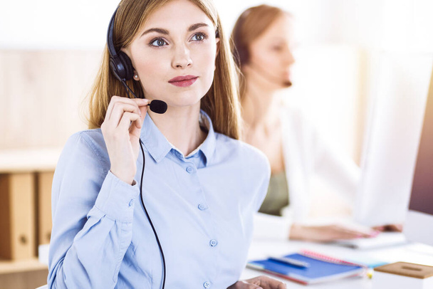 Toned portrait of call center operator at work. Group of people in a headset ready to help customers. Business concept - Foto, Imagem
