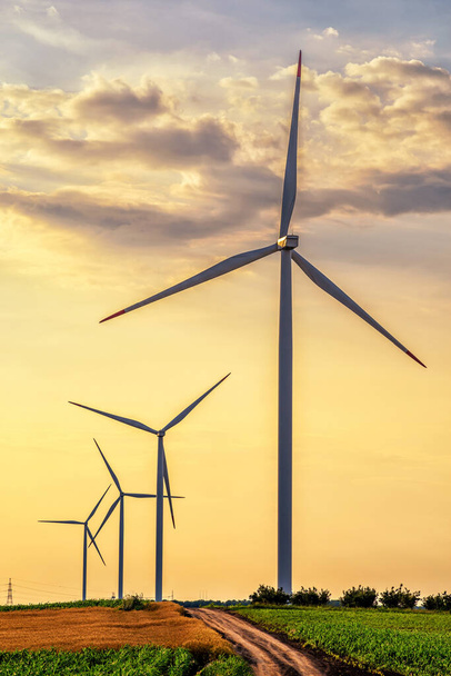 Megújuló energia szélerőmű turbinákkal és generátorokkal a naplementében, gyönyörű táj  - Fotó, kép