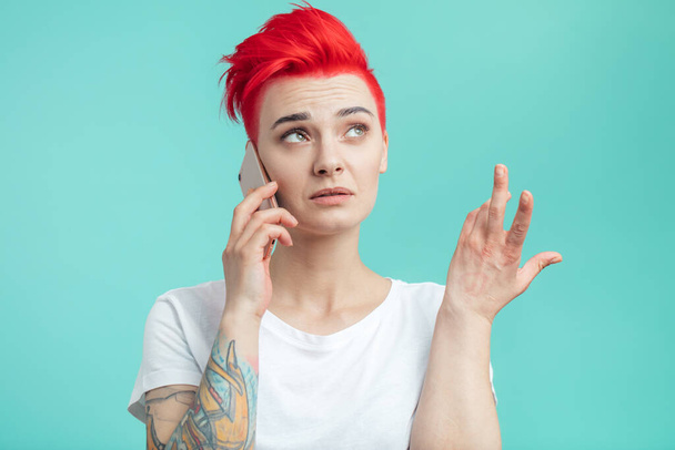 молодая привлекательная женщина с помощью жестов во время разговора по телефону - Фото, изображение
