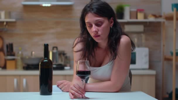 Vrouw die naar een glas wijn kijkt - Video