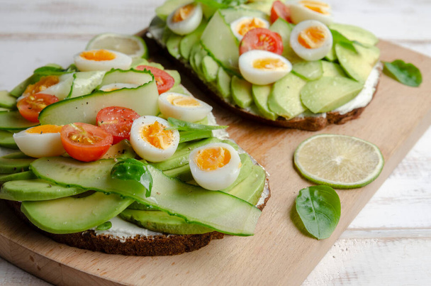 Avocado sandwich with quail eggs and cherry - Photo, Image