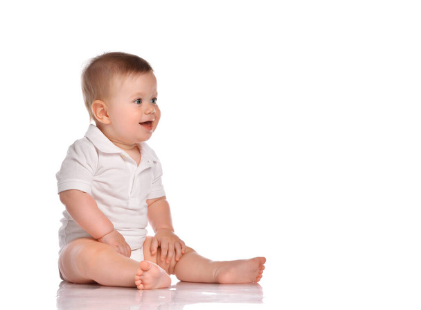 Cute little boy in white bodysuit sitting isolated on white - Photo, Image