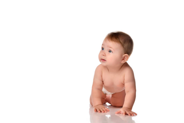 Baby crawling on floor looking aside front view - Foto, Bild