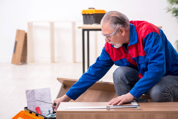 Old male carpenter working indoors - Photo, Image
