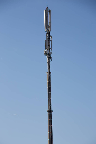 Μακρύς πύργος κινητής τηλεφωνίας μπροστά από τον γαλάζιο ουρανό - Φωτογραφία, εικόνα
