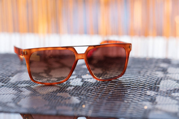 Modelo de gafas de sol clásicas disparar en un primer plano día soleado. Enfoque selectivo - Foto, imagen
