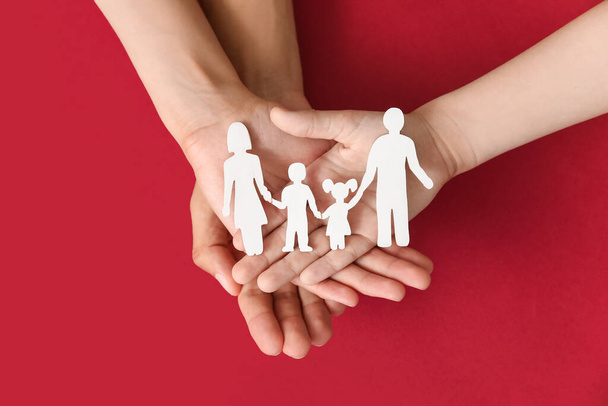 Handen van de familie met menselijke figuren op kleur achtergrond - Foto, afbeelding