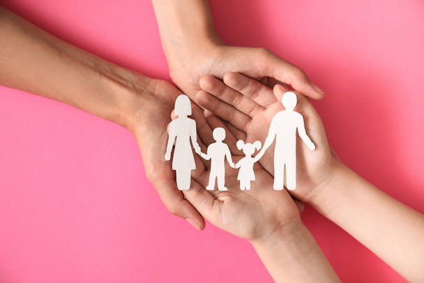 Hands of family with human figures on color background - Fotoğraf, Görsel